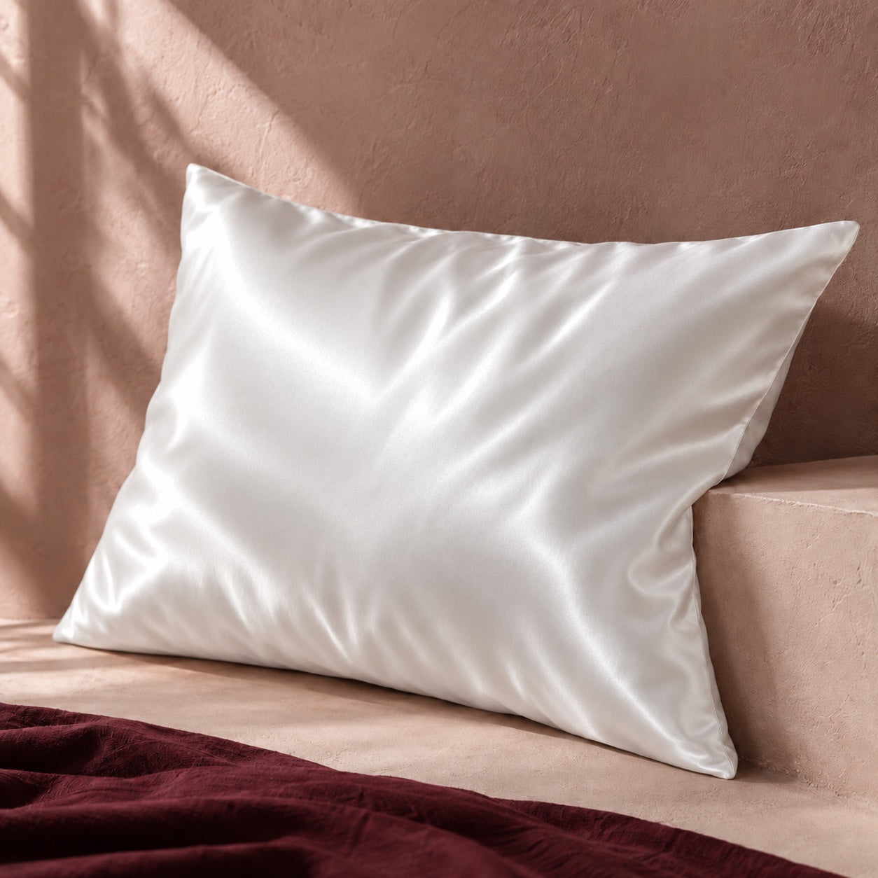 La taie blanche en soie avec des reflets satinés sur un fond rose